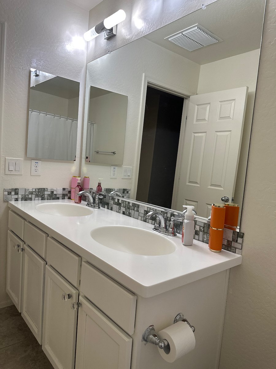 Upstairs shared bathroom with double sinks and storage