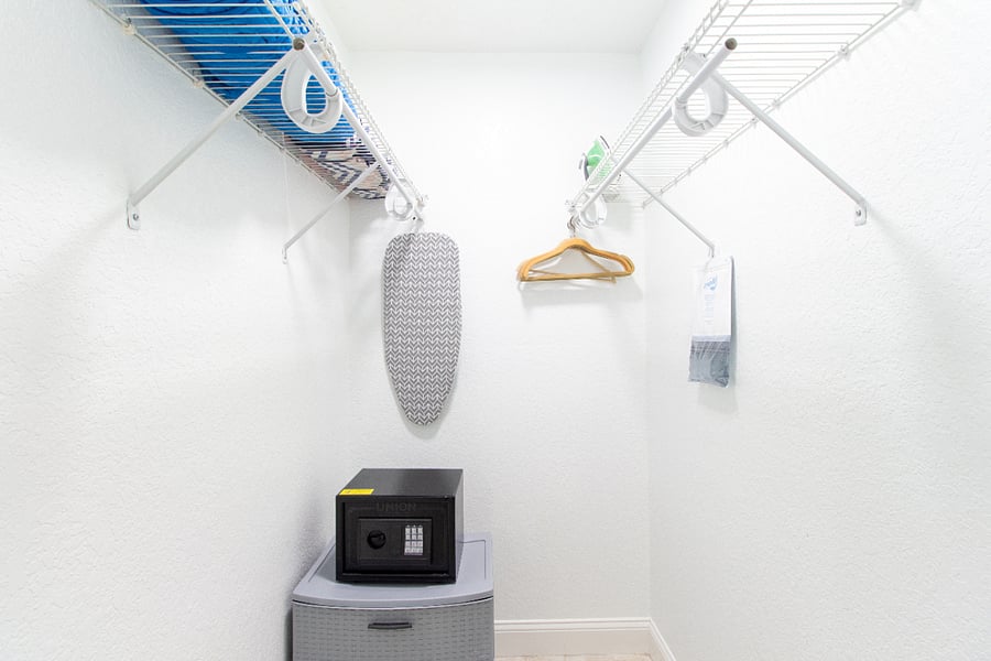 Walk-in closet with iron and ironing board and security box.
