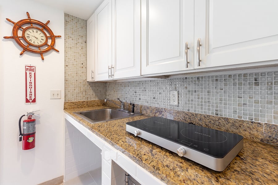 The kitchenette includes a cooktop, sink, fridge, washer and dryer, and dining table!