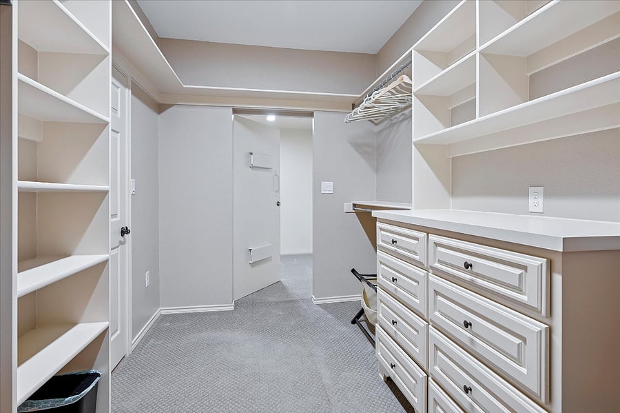 Dedicated walk-in closet for him, offering generous storage and organization
