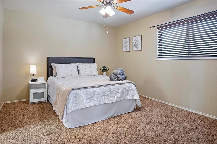 Relaxing upstairs bedroom with a queen bed, wall-mounted TV, attached full bathroom,