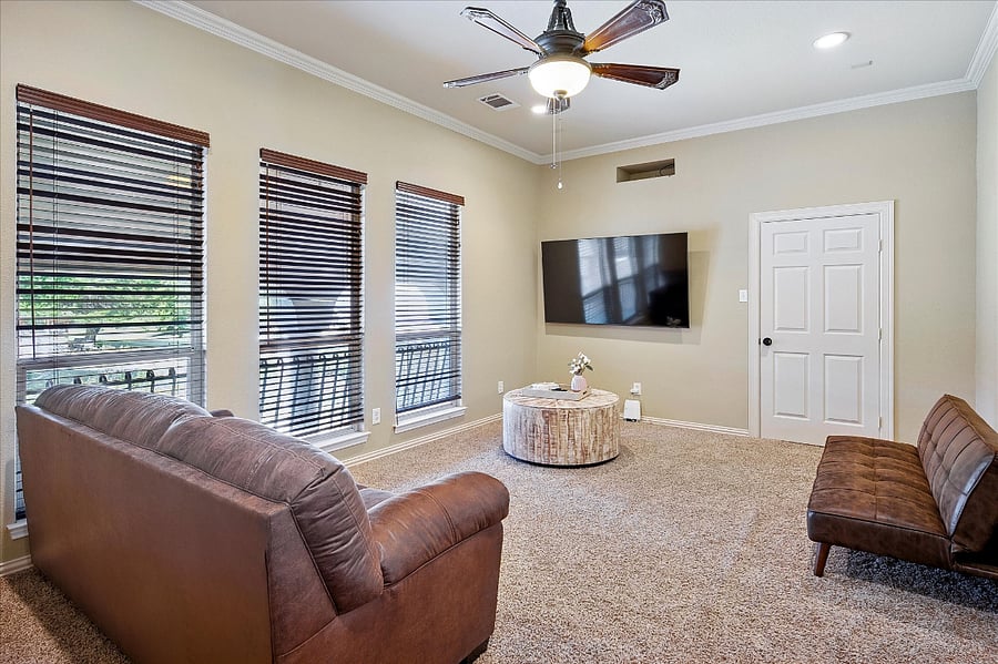 Thoughtfully designed multi-use flex room featuring a queen-size pull-out sofa bed, double futon, wall-mounted TV, and a dedicated yoga space with mat and blocks. Perfect for extra guests, entertainment, or wellness activities