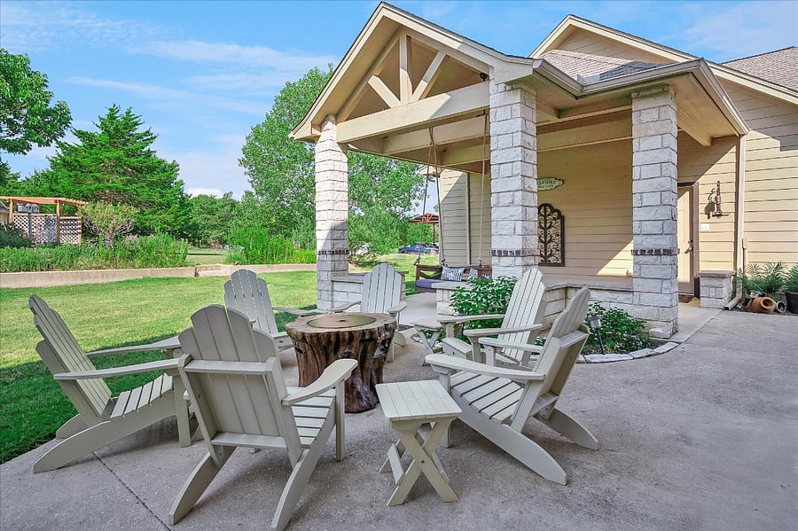 Inviting back patio with a picnic table, comfortable seating, fire pit, and BBQ grill surrounded by serene nature views, perfect for relaxing weekends and memorable family gatherings