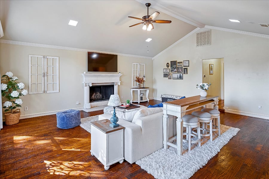 Inviting spacious living room with a wall-mounted TV, warm fireplace, and ample seating, perfect for relaxing and gathering