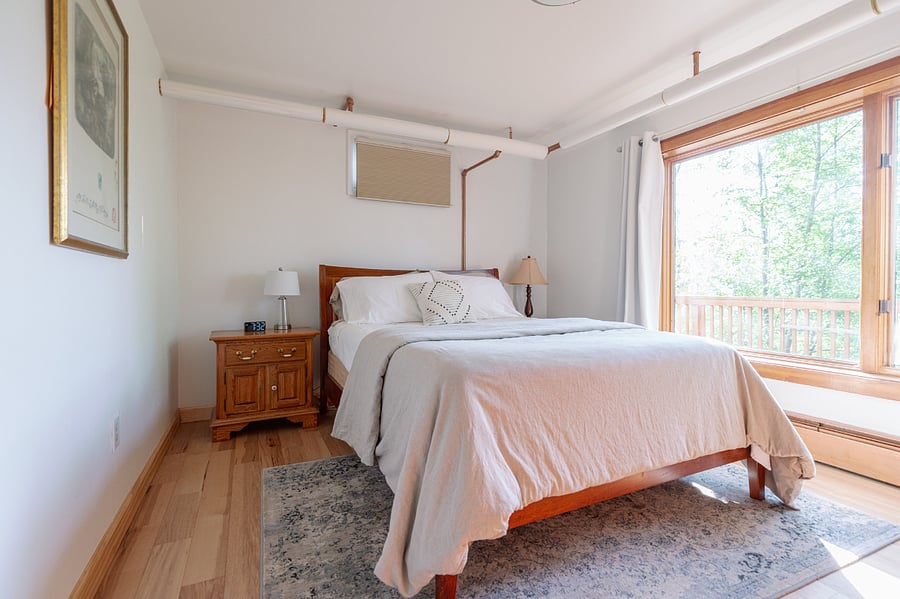 Larger bedroom w/queen-size bed and large window overlooking the deck