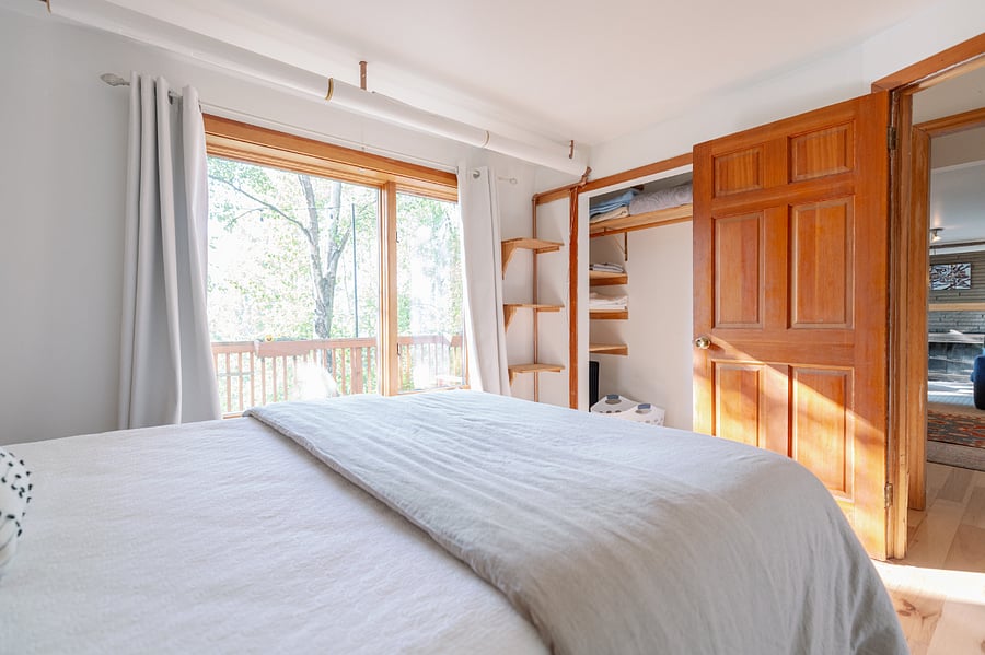 Larger bedroom w/queen-size bed and large window overlooking the deck