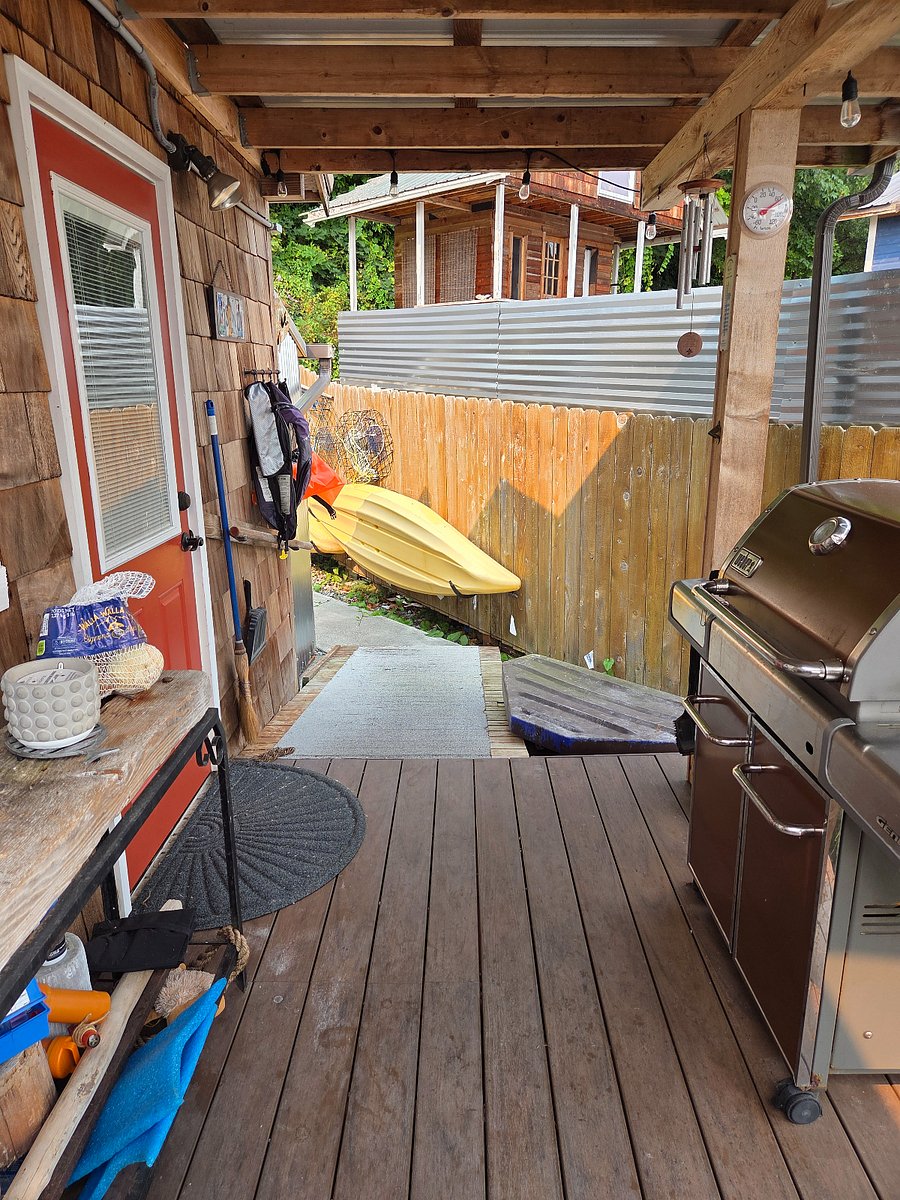 BBQ on main cabin deck, kayaks available for use and orange door is access to washer and dryer.