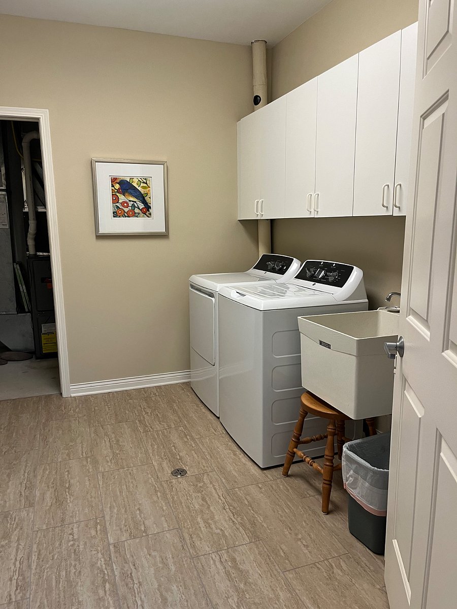 Utility room with new washer and dryer and sink.