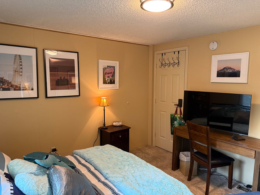 Remote control lighting with various settings for lamp over corner chair. Small lamp has switch next to bed.