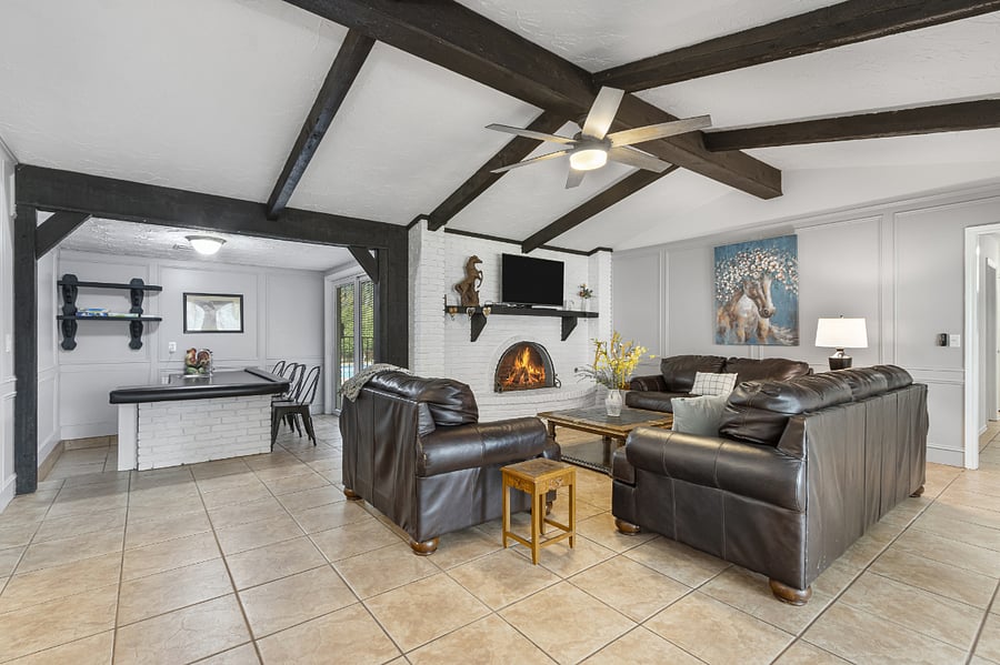 One of two large family rooms with large smart TV, sofas and fireplace.