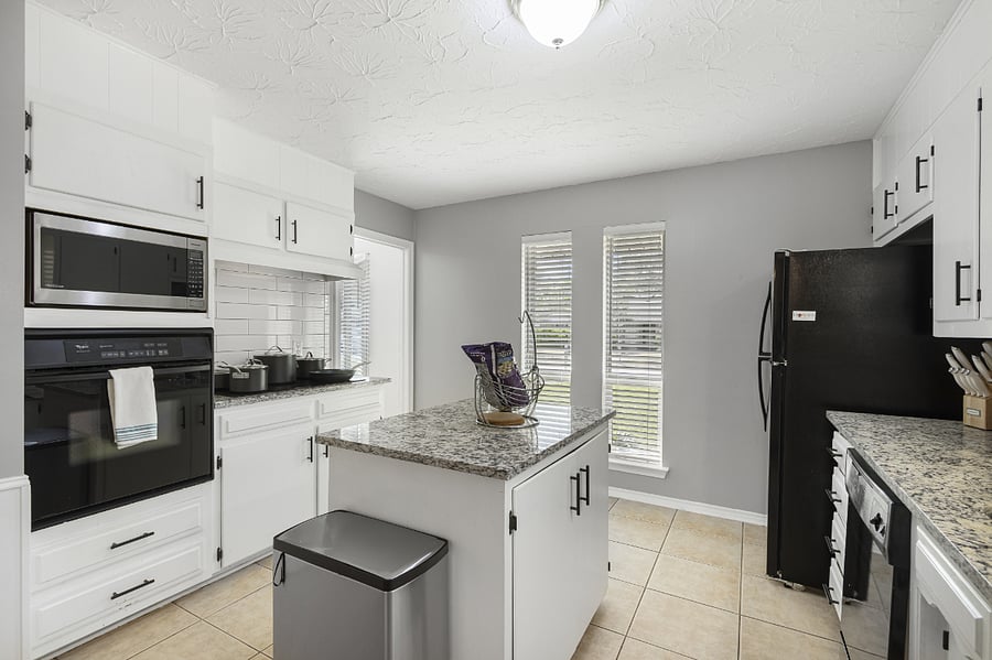 Island/bar seating plus a large open kitchen offers fridge/freezer, dishwasher, many cabinets, and counterspace for prep, microwave, stovetop, and oven.