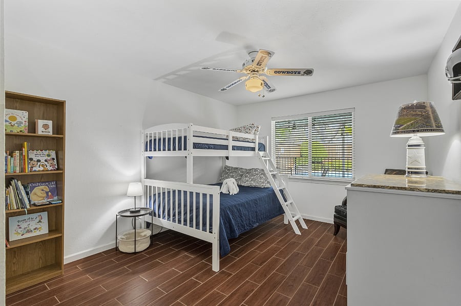 3rd of 4 bedrooms with a full size bed under a twin bunk set. Also, ceiling fan, kids' books, chest of drawers, and mattresses encased in a covering we wash and sanitize after every guest, which keeps the mattresses in new condition. Large closet and view of the backyard
