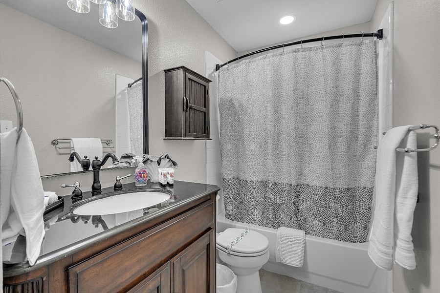 Hall bathroom with a tub/shower combo, providing easy access from three guestrooms.