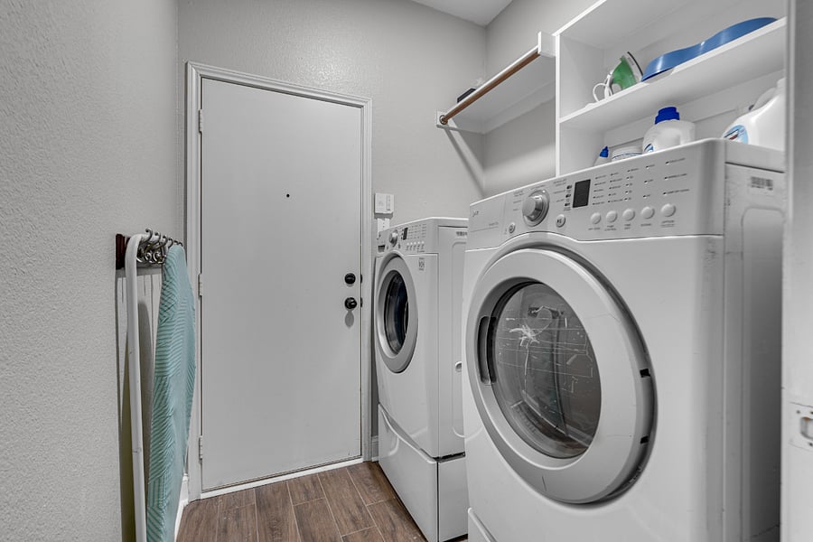 Washer and dryer in laundry room with iron and ironing board