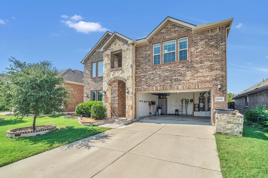 Beautiful two-story brick and stone home with a covered entry, two-car garage, landscaped yard, and Tesla solar panels. Spacious driveway provides plenty of parking.