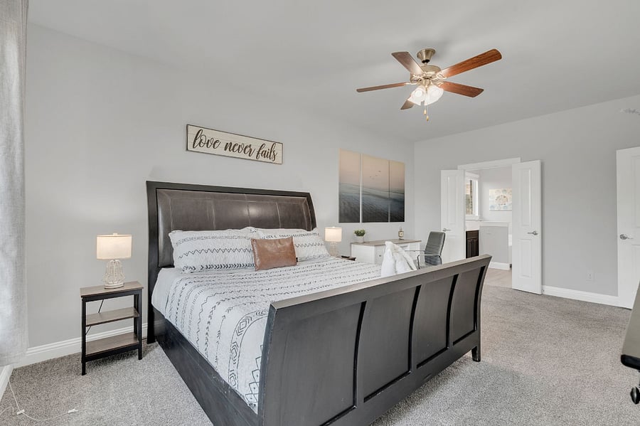 Spacious master with ceiling fan, seating, and direct ensuite access