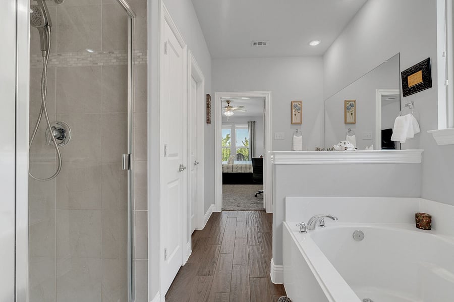 Ensuite bath with dual sinks, soaking tub, walk-in shower, and walk-in closet