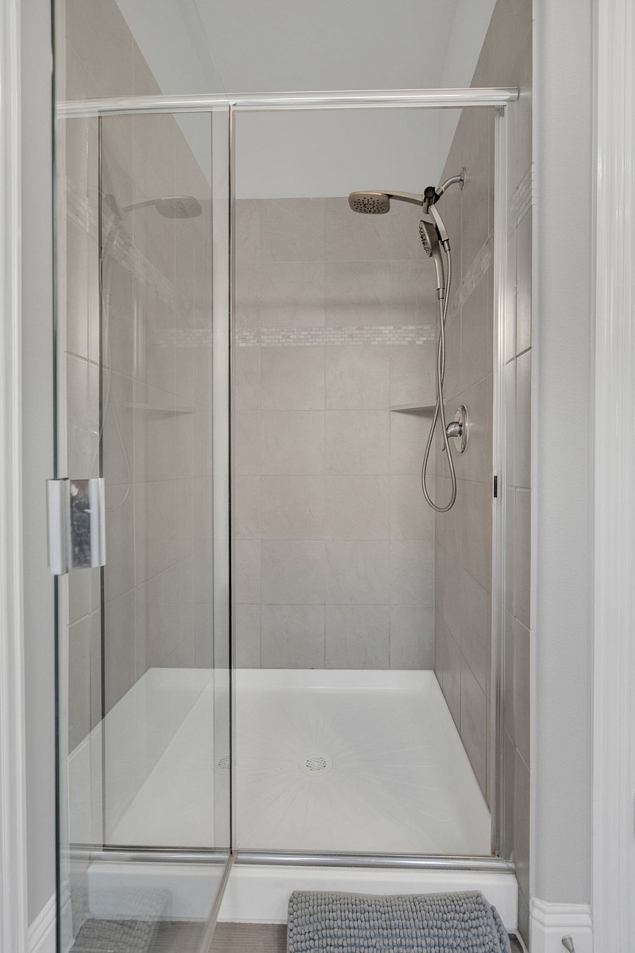 Walk-in glass shower with modern tile and rainfall showerhead