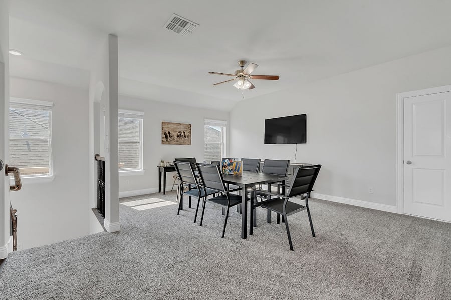 Upstairs loft gameroom with Smart TV, large table seating for game nights, projects, or team gatherings, plus a tucked-away desk and chair under the far windowperfect for work or study.