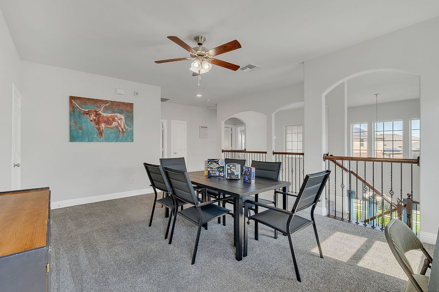 Upstairs loft gameroom with Smart TV, large table seating for game nights, projects, or team gatherings, plus a tucked-away desk and chair under the far windowperfect for work or study.