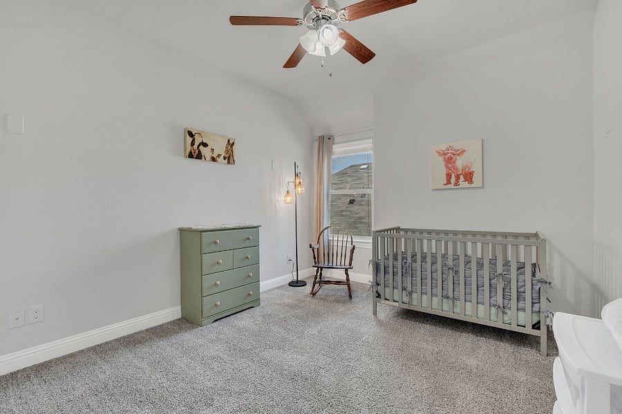 Upstairs 5th bedroom  currently set up as a nursery with a crib, dresser, changing space, and rocking chair. Closet space included. Can be converted to a twin bedroom upon request for additional flexibility.