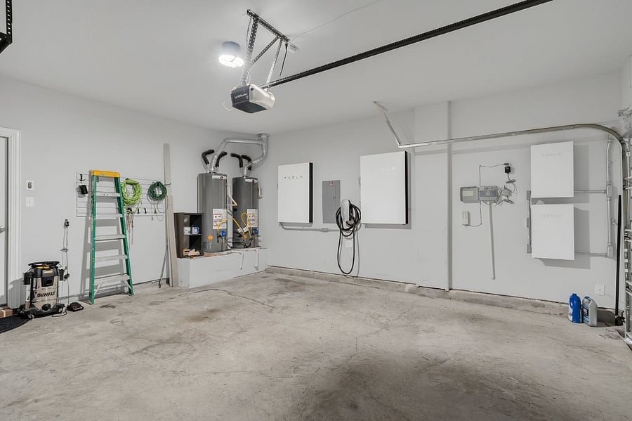 Spacious garage equipped with Tesla solar system, Powerwalls, and EV charger. Features two full-size hot water heatersensuring no shortage during multiple showers, laundry, and dishwasher use.