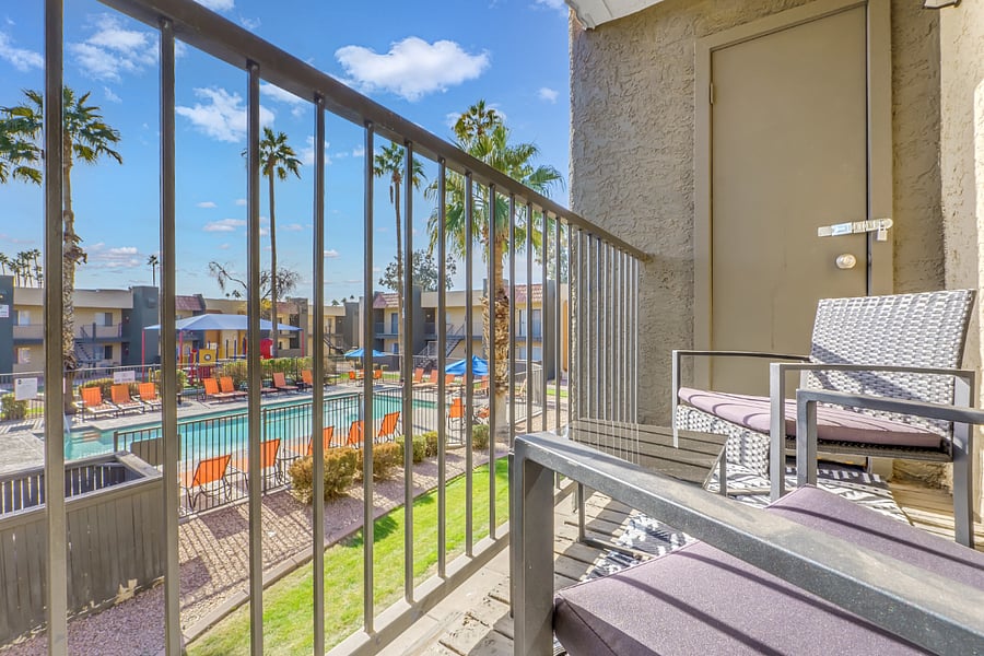 Private balcony overlooking resort like pool.