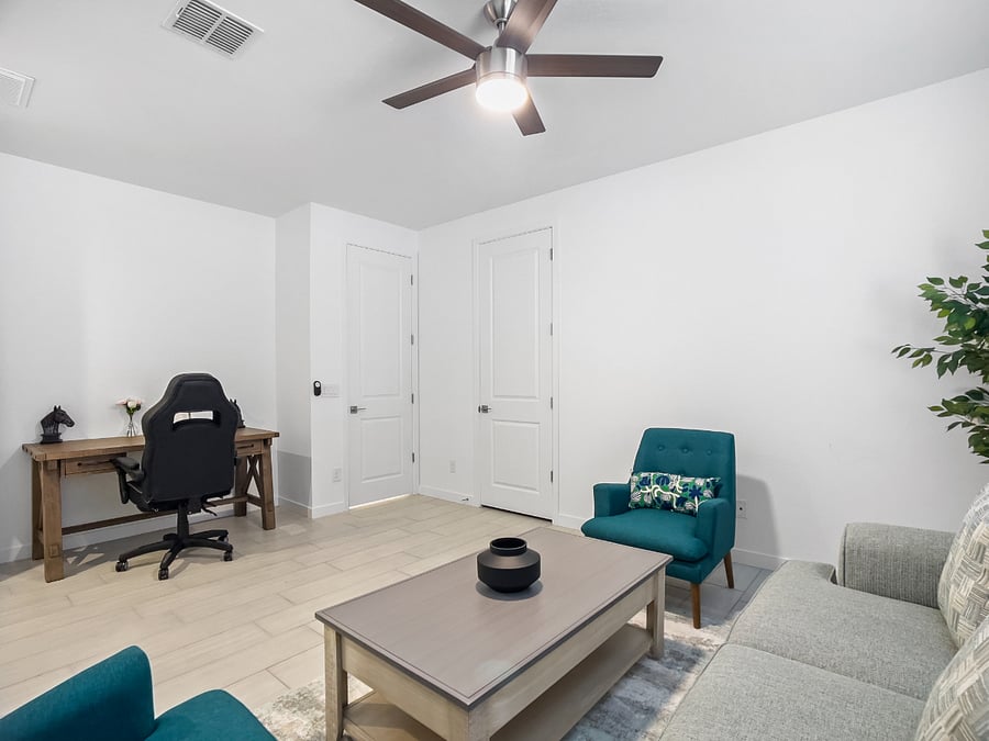 Junior suite with a living room, dedicated workspace, ergonomic chair, attached bedroom, private bathroom, a new king-size bed with memory foam mattress, two nightstands with lamps, and a storage closet. Ceiling fan in the living room and bedroom.

