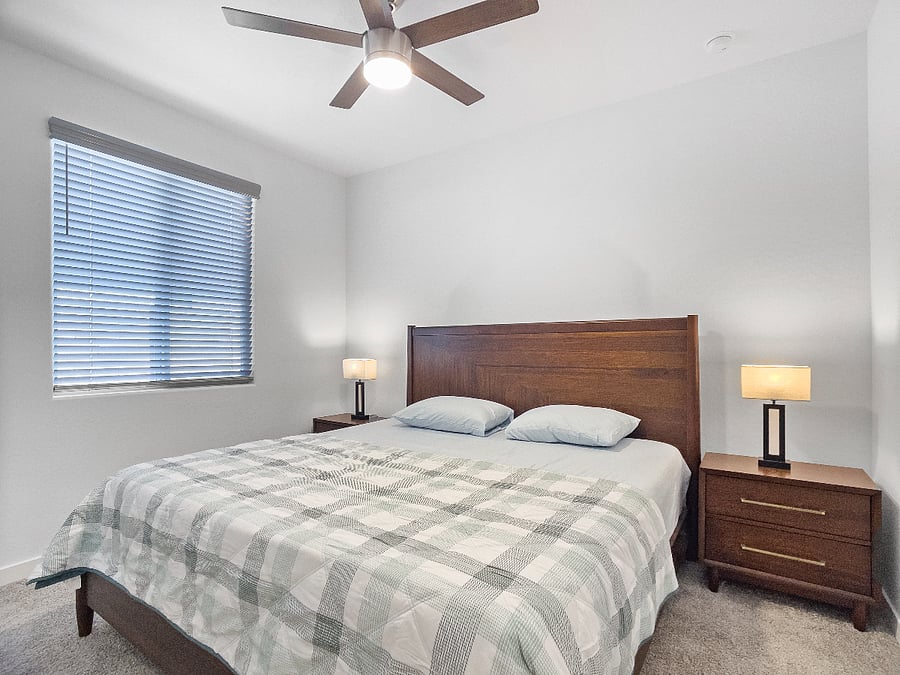 2nd bedroom attached to the second suite with a brand-new king-size memory foam bed, two bedside lamps, ceiling fan, private full bathroom, and storage closet.
