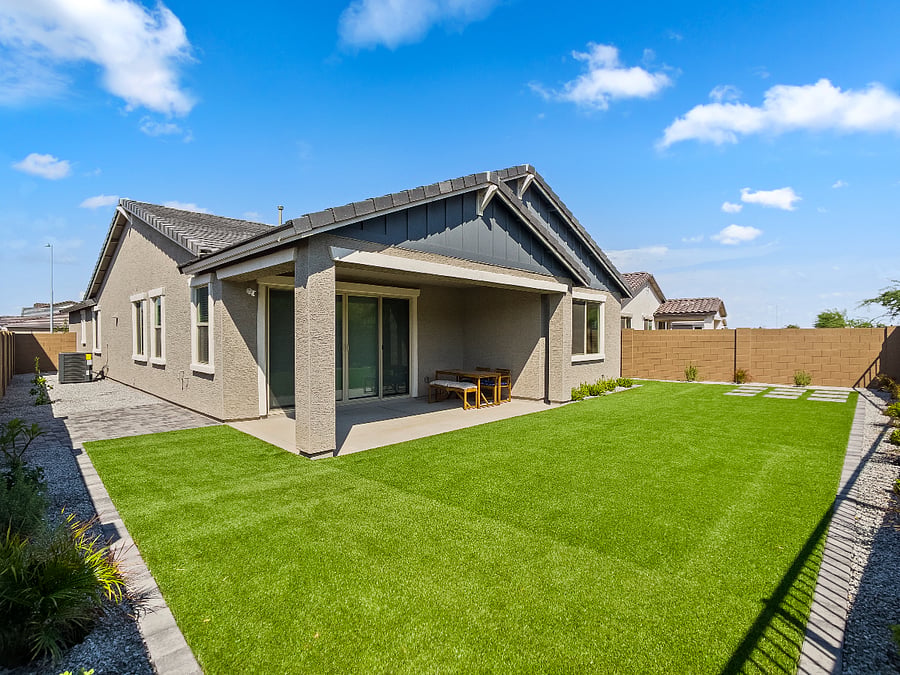 Beautifully landscaped backyard featuring low-maintenance artificial turf, live plants, and full fencing for your pets. Relax on outdoor couches, enjoy family evenings, and unwind under charming ambient lighting for late-night gatherings