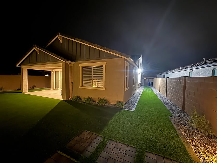 Beautifully landscaped backyard featuring low-maintenance artificial turf, live plants, and full fencing for your pets. Relax on outdoor couches, enjoy family evenings, and unwind under charming ambient lighting for late-night gatherings