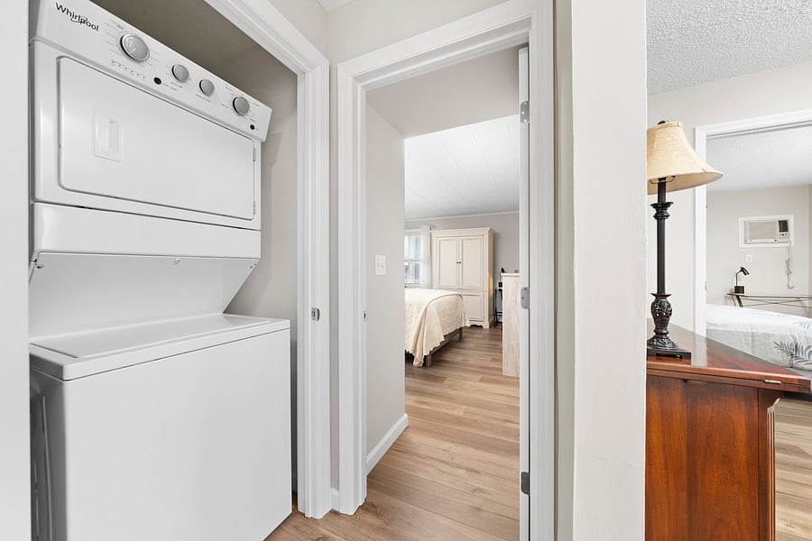 Private stacked washer and dryer inside the apartment, tucked into a hall closet between the bedrooms.