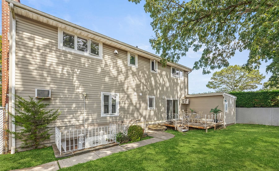 View of the fenced backyard and the deck, reached directly from the living room. Includes an outdoor table and seating for four.