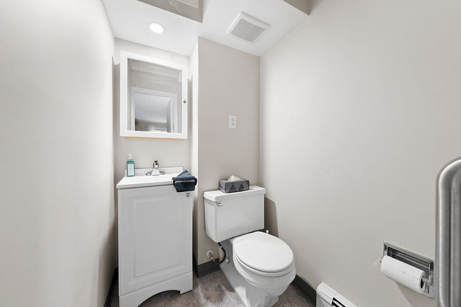 Private half bath directly off the large queen bedroom, with a sink, mirror, and toilet.