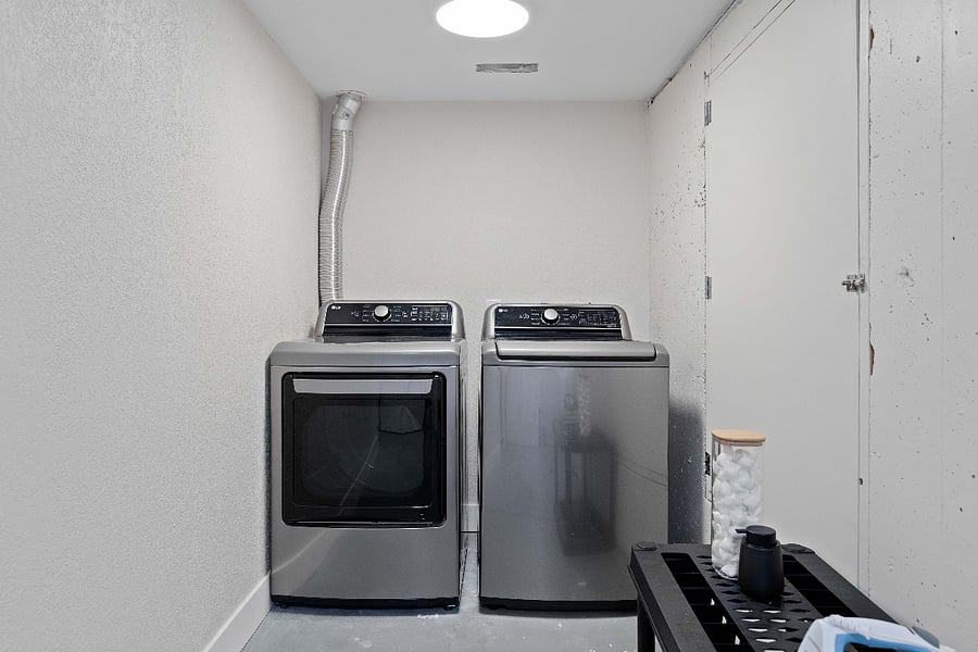 Convenient laundry area equipped with a modern LG washer and dryer set, plus a utility cart for detergent and essentials. A clean and functional space for all your laundry needs.