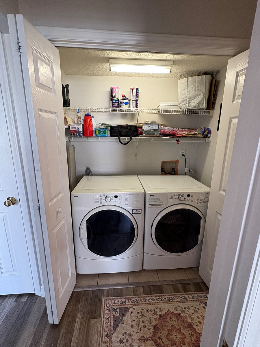 Laundry closet with laundry needs (detergent, wool balls for dryer, and ironing board), paint and popcorn ceiling touch up material, tool box, and gift wrapping