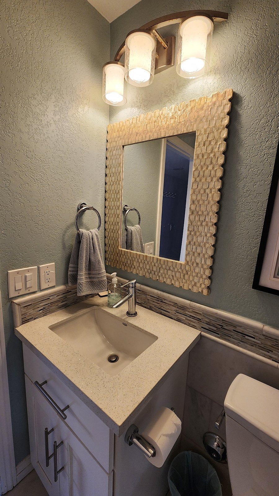 1st floor bathroom with full marble tile and quartz sinktop, large mirror and storage vanity