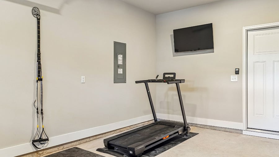 Garage with TV, TRX system, and treadmill