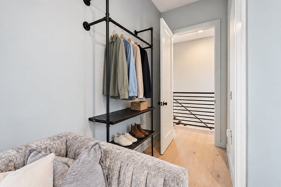 This bedroom includes an open wardrobe with hanging space and shelving for folded clothing. The bedroom's traditional closet is reserved for owner storage and is not accessible to guests.