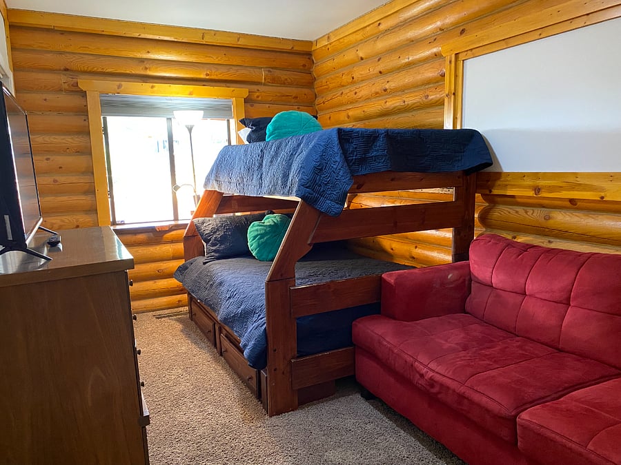 Bedroom 4 on the first floor has a bunkbed, a sofa and a TV.