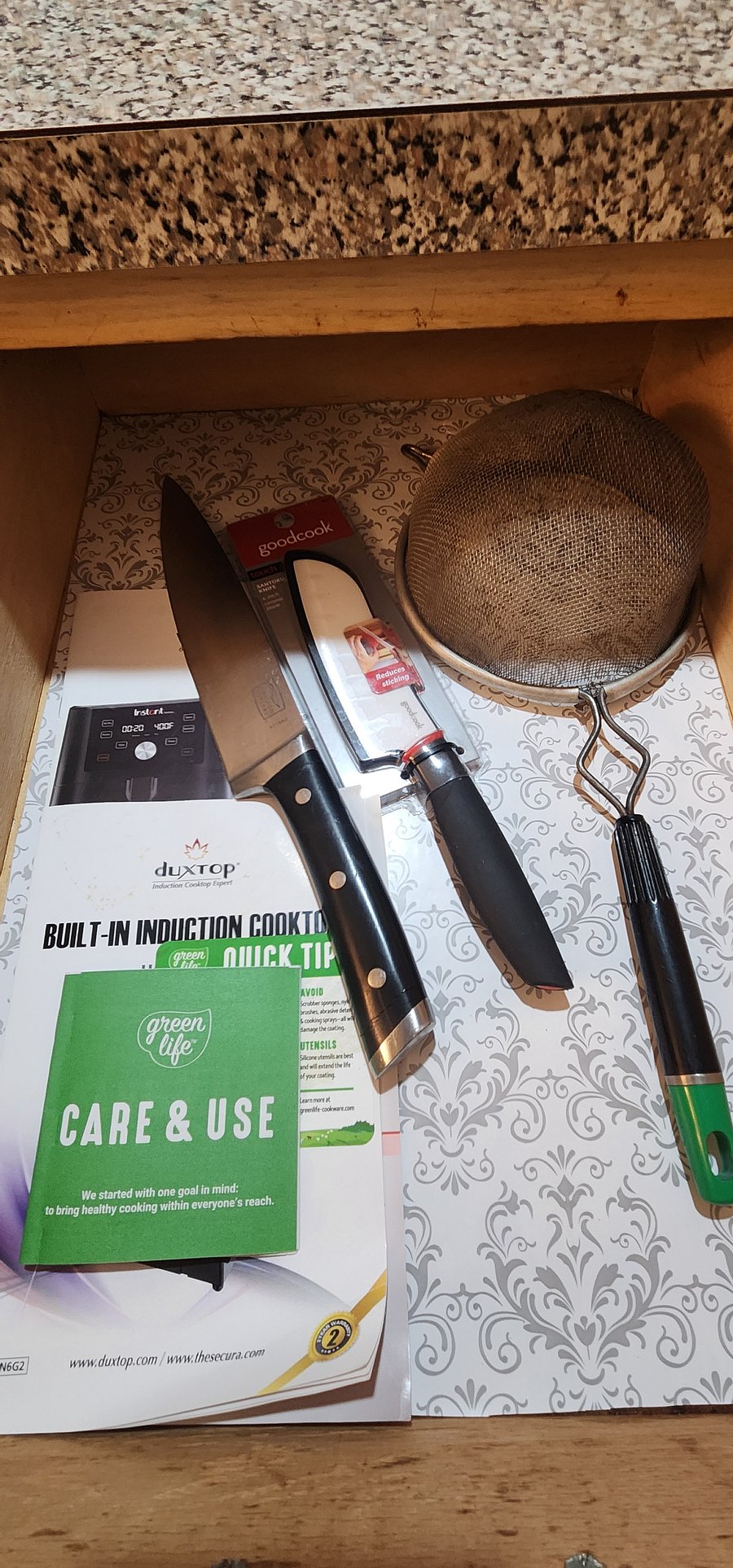 Chef knives, strainers and instruction manuals for the air fryer and induction burner