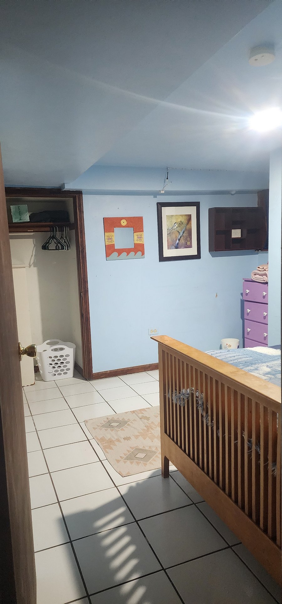Closet contains a laundry basket, extra bedding and towels, hangers and other amenities