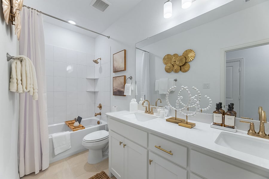 Luxury secondary bathroom with shower and soaking tub combo and double sinks. Equipped with extra essentials: cotton pads, Q-tips, Kleenex tissue, shower caps and makeup removal wipes.