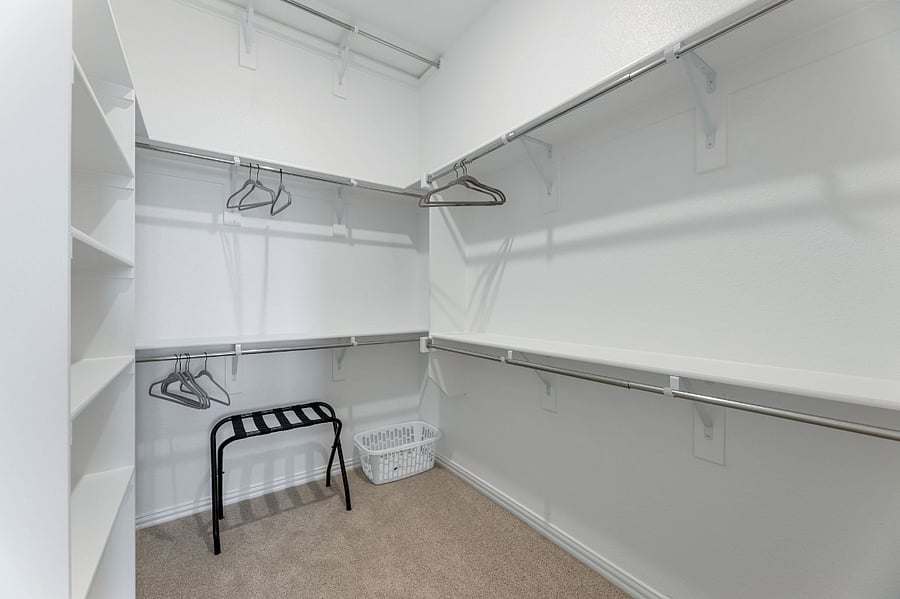 Spacious "Her" master closet with dedicated shoe cubbies.