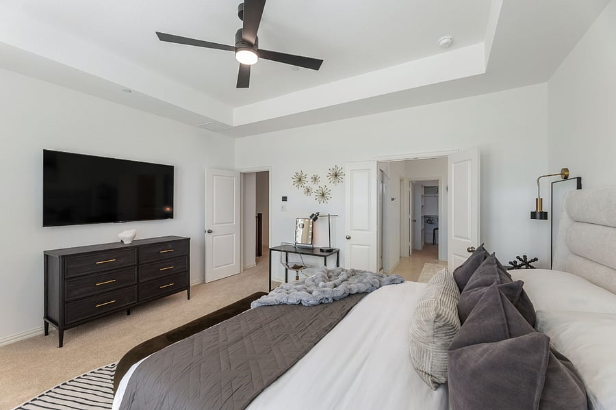 Luxurious Master Bedroom with 10ft ceilings and lots of natural light. Features a 65" Smart TV, walk-in His and Hers closets, and a dedicated workstation.