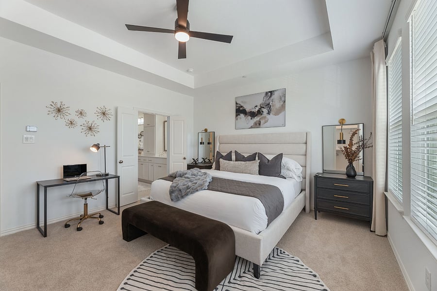 Luxurious Master Bedroom with 10ft ceilings and lots of natural light. Features a 65" Smart TV, walk-in His and Hers closets, and a dedicated workstation.