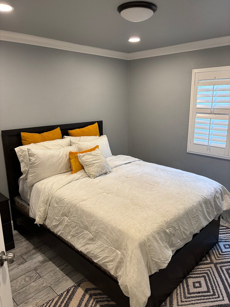 bedroom 1 queen bed w night stand and window shutters