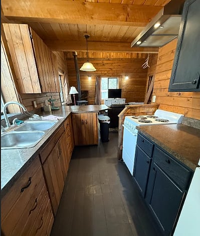 Kitchen includes stovetop, oven, sink, full refrigerator and freezer, microwave, coffee maker, cookware (pots and pans), utensils, cups, plates, bowls, mugs.