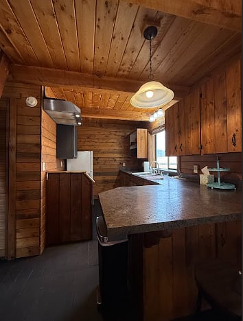 View of kitchen from the living room. Kitchen includes bar with two barstools.