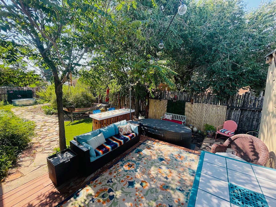 Deck off of kitchen with outdoor dining room table, outdoor bar, sofa, hammock, and hot tub